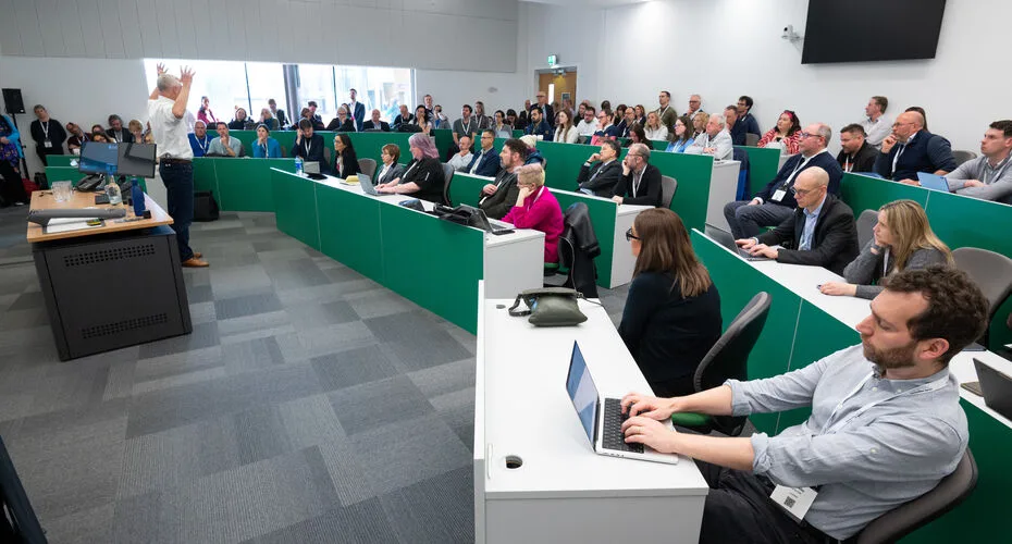 A large group of people seated in a classroom during the digital universities uk 2024 event at the university of exeter.