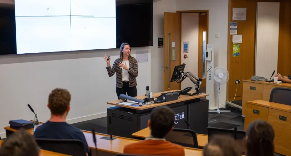 A participant presents in a university of exeter business school lecture theatre.