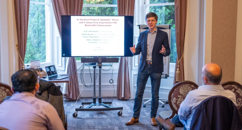 A man presenting to an audience, engaging with the group while using visual aids to enhance his message.