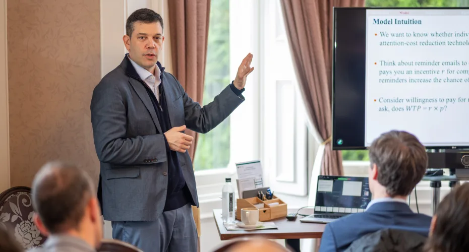 Judd Kessler delivers a presentation to a seated audience, highlighting key points with gestures.