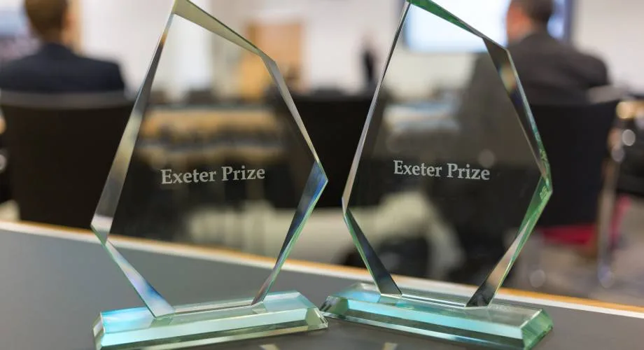 Two exeter prize awards standing on a table.