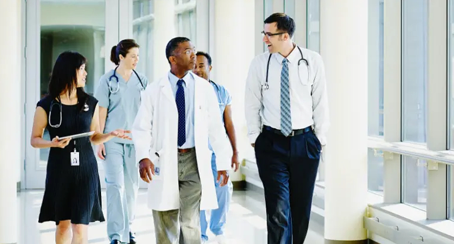 Five health care practitioners walking down a corridor