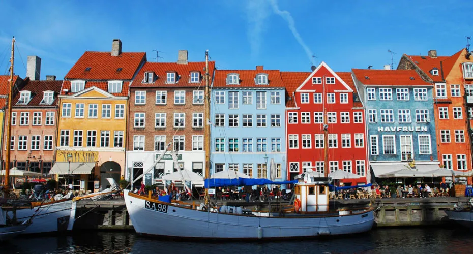 A scenic view of a row of brightly colored buildings in Copenhagen, reflecting the city's unique architectural style.