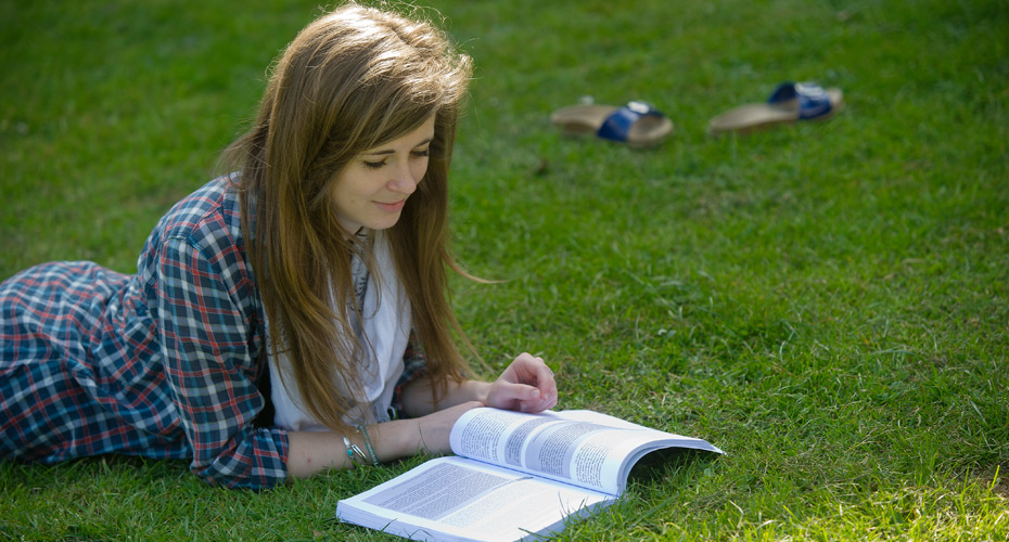 Student reading a book on campus